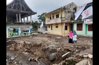 Hj Nevi di antara rusaknya rumah warga karena Galodo Sumbar 11 Mei 2024 lalu. (hd)