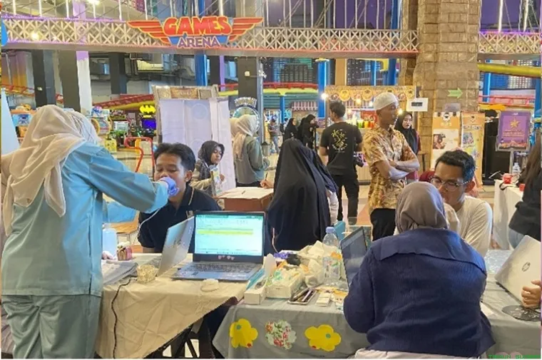Dokter dari GAIA Dental Clinic memeriksa gigi pengunjung menggunakan kamera intraoral di booth acara Waste to Wonder Transmart Padang. (Foto: Ist)