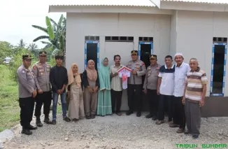 Kapolres Pasaman Barat AKBP Agung Tribawanto, S.Ik. menyerahkan kunci rumah layak huni kepada Alia Chandra (48) di Lintang Selatan Batang Toman, Nagari Lingkuang Aua, Kecamatan Pasaman, Kamis (26/6/2025). (Foto: Ist)