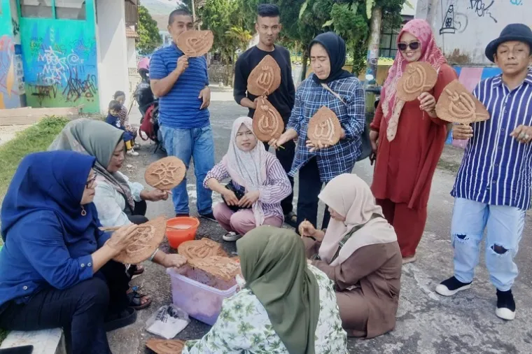 Peserta pelatihan dari kelompok disabilitas tengah belajar mengolah limbah serbuk kayu menjadi karya seni kreatif bersama tim dosen dan mahasiswa ISI Padangpanjang. (Foto: Ist)