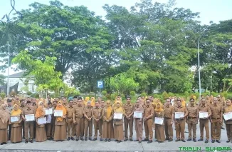 Plh Sekda Kota Padang, Corri Saidan, menyerahkan penghargaan Employee of The 1st Semester 2025 kepada ASN berprestasi saat apel gabungan di Kompleks Balai Kota Aie Pacah, Senin (7/7/2025). (Foto: Ist)