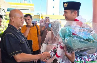 Ketua Umum DPW PKPS Sumbar, H Budi Syukur Dt Bandaro Jambak, mengalungkan bunga kepada Habib Burhan, siswa SMAN 1 Pancung Soal yang sukses bertugas sebagai Danru 17 Paskibra Nasional di Istana Negara. (Foto: Ist)