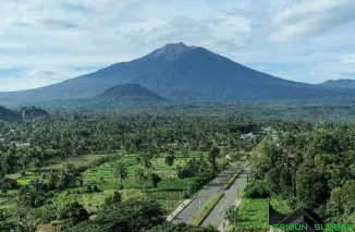 Pendaki melintasi jalur baru Gunung Kerinci via Solok Selatan yang dibuka melalui program TMMD 2025, dengan latar hutan alami dan panorama Danau Bukit Bontak. (Foto: Ist)