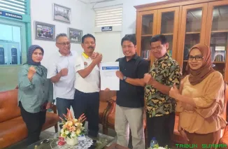 Ketua SIWO PWI Sumbar Syaiful Husein menyerahkan surat rekomendasi dukungan kepada Hamdanus untuk maju sebagai calon Ketua KONI Sumbar, disaksikan Ketua PWI Sumbar Widya Navies di Kantor PWI Sumbar. (Foto: Ist)