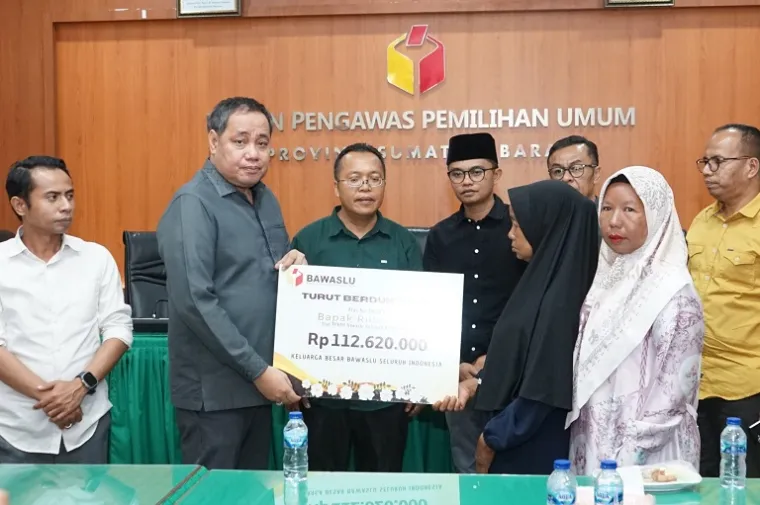 Anggota Bawaslu RI Herwyn JH Malonda menyerahkan bantuan dana kerohiman sebesar Rp112.620.000 kepada ahli waris almarhum Rudi Yanto, staf Sekretariat Bawaslu Dharmasraya, di Kantor Bawaslu Provinsi Sumatera Barat, Senin (6/10/2025). (Foto: Ist)