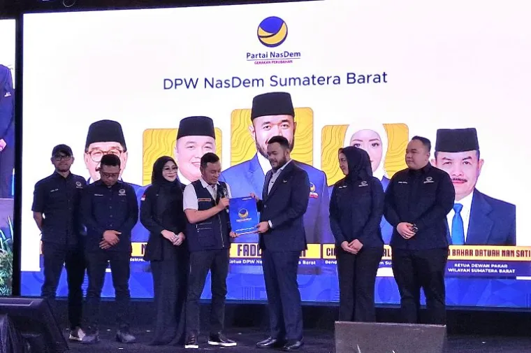 Willy Aditya menyerahkan SK Kepengurusan DPW Partai NasDem Sumbar kepada Fadly Amran, Ketua DPW Partai NasDem berserta pengurus. (Foto: Ndo)
