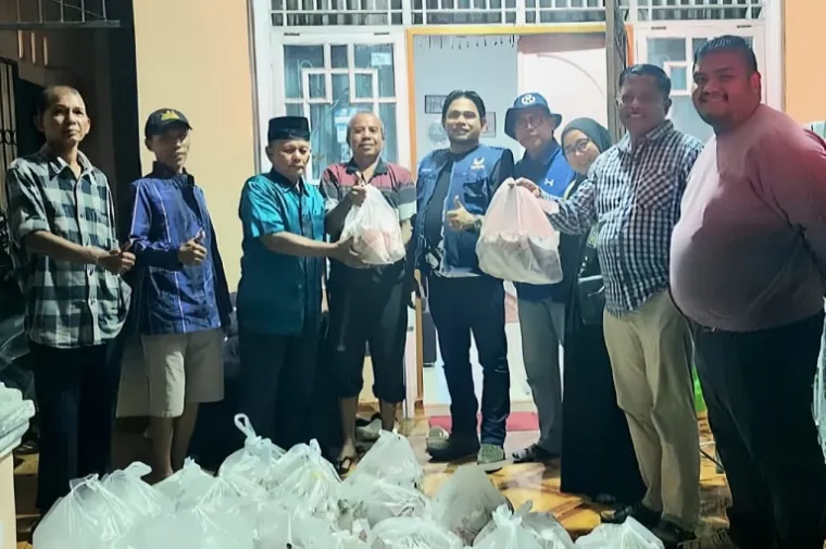 Pengurus Partai NasDem Kota Padang saat mendistribusikan ratusan bungkus nasi kepada warga terdampak banjir di Maransi dan Dadok Tunggul Hitam, Kecamatan Koto Tangah, Padang, Selasa sore hingga malam (25/11/2025). (Foto: Ist)