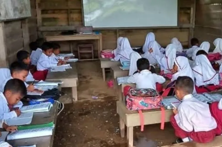 Seorang guru memberikan pelajaran di sekolah terpencil di daerah 3T, berjuang mengajar meski fasilitas terbatas. (Foto: Ist)