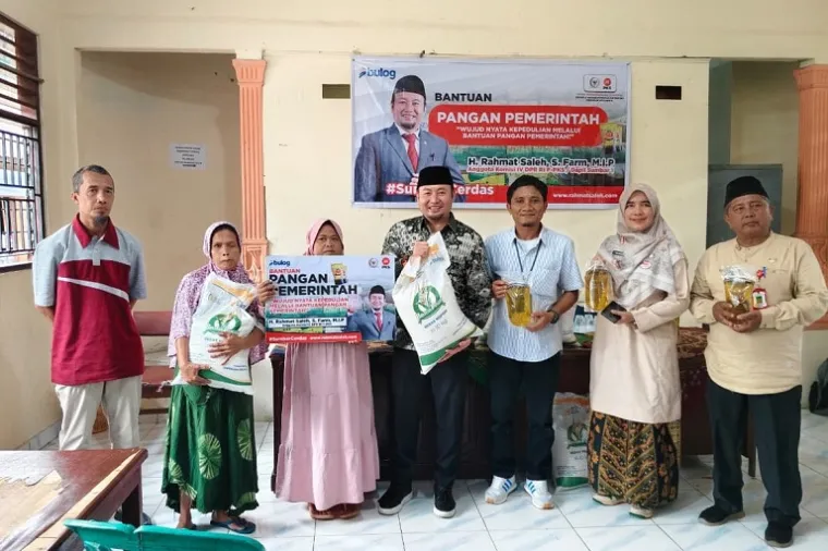 Rahmat Saleh menyerahkan bantuan beras dan minyak goreng kepada warga Binuang Kampung Dalam, lokasi yang pernah menjadi tempat ia berjuang sebagai mahasiswa. (Foto: Ist)