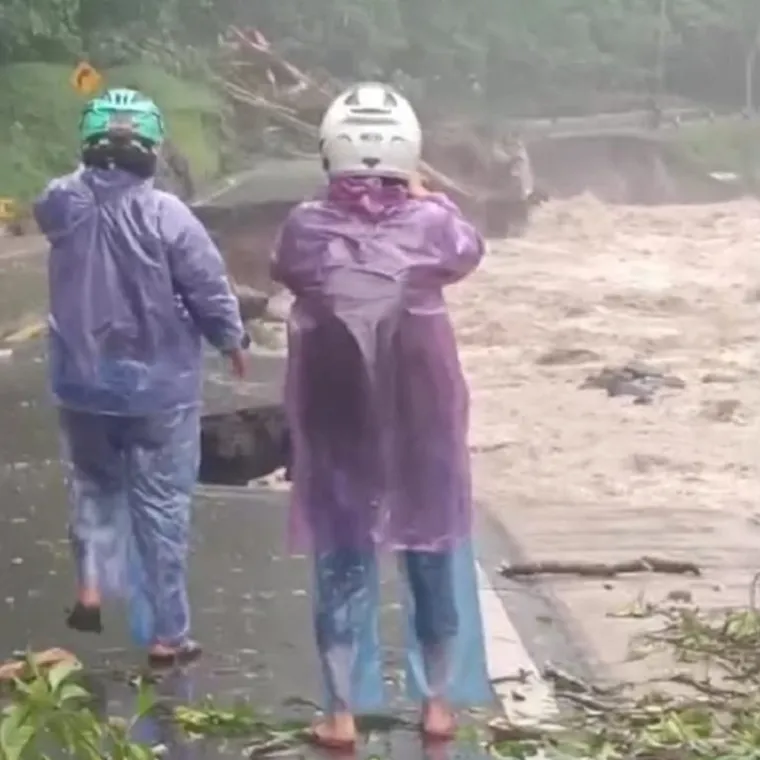 Petugas kepolisian mengamankan lokasi jalan amblas di depan Pemandian Mega Mendung, Lembah Anai, yang membuat akses Padang--Bukittinggi lumpuh total. (Foto: Ist)