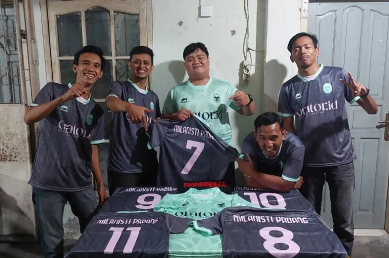 Capo Milanisti Indonesia Sezione Padang, Berry Syamtariko (tengah) bersama anggota memperlihatkan jersey baru hasil kolaborasi dengan Kabau Apparel di Kafe Teh Talua Malimpah Ucok, Padang, Jumat malam (7/11/2025). (Foto: Ist)