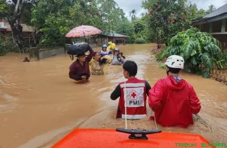 Relawan PMI mengevakuasi warga yang terjebak banjir menggunakan perahu di Kecamatan Lubuk Sikarah, Kota Solok. (Foto: Ist)