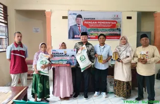 Rahmat Saleh menyerahkan bantuan beras dan minyak goreng kepada warga Binuang Kampung Dalam, lokasi yang pernah menjadi tempat ia berjuang sebagai mahasiswa. (Foto: Ist)