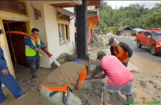 Petugas PT BRM bersama TNI-Polri mengoperasikan alat berat untuk membersihkan material galodo di Jurong Padang Laweh, Malalo. (Foto: Ist)