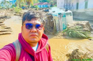 Seorang jurnalis di Padang tetap melakukan peliputan banjir meski rumah dan peralatannya turut terdampak banjir. (Foto: Ist)