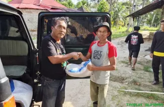 Ucok (FWP-SB) menerima bantuan dari relawan di lokasi banjir yang mulai mengering di Kecamatan Koto Tangah. (Foto: Ist)