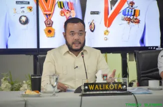 Wali Kota Padang Fadly Amran mengikuti rapat virtual bersama KLH/BPLH RI membahas revitalisasi Sungai Batang Arau dan pengadaan Bus Trans Padang berbasis baterai dari Rumah Dinas Wali Kota Padang, Selasa (28/1/2026). (Foto: Ist)