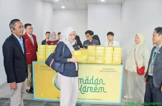 Komisaris Independen Angkasa Pura Indonesia Imelda Sari saat membagikan takjil kepada penumpang di Bandara Internasional Minangkabau yang menghadirkan suasana Ramadan dengan sentuhan budaya Minangkabau, Selasa (17/3/2026). (Foto: Ist)