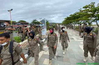 Petugas Satpol PP Kota Padang berjaga di kawasan Pantai Padang untuk mengamankan lonjakan wisatawan selama libur Lebaran 2026. (Foto: Ist)