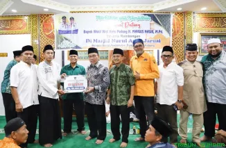 Wakil Wali Kota Padang Maigus Nasir menyerahkan bantuan hibah dari Pemerintah Kota Padang kepada pengurus Masjid Nurul Amal Jaruai saat Safari Ramadan di Kelurahan Bungus Barat, Kecamatan Bungus Teluk Kabung, Kamis (12/3/2026). (Foto: Ist)