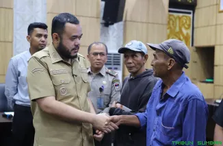 Wali Kota Padang Fadly Amran menyerahkan bantuan stimulan perbaikan rumah kepada warga terdampak bencana hidrometeorologi di Balai Kota Aia Pacah, Selasa (28/4/2026). (Foto: Ist)