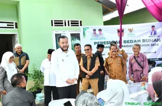 Wali Kota Padang Fadly Amran menyerahkan kunci rumah secara simbolis kepada keluarga penerima manfaat program bedah rumah yang diinisiasi Baznas Kota Padang di Kecamatan Kuranji. (Foto: Ist)