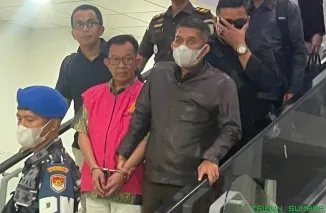 Tersangka kasus korupsi Beny Saswin Nasrun tiba di Bandara Internasional Minangkabau dengan pengawalan ketat, setelah sebelumnya diamankan di Jakarta. (Foto: Ist)