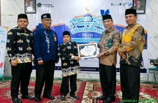 Wakil Wali Kota Padang Maigus Nasir meyerahkan paket lebaran secara simbolis kepada perwakilan anak yatim dan penyandang disabilitas di Aula Kantor Kemenag Kota Padang, Kamis (25/6/2026). (Foto: Ist)