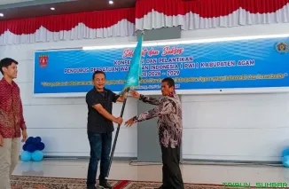 Ketua PWI Sumbar Widya Navies menyerahkan pataka organisasi kepada Mursyidi yang baru terpilih sebagai Ketua PWI Kabupaten Agam masa bakti 2026--2029, Jumat (26/6/2026). (Foto: Ist)