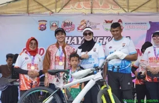 Suasana meriah kegiatan Road to Police Woman Run 2026 di Jembatan Kabel Sungai Dareh, Dharmasraya, Minggu (14/6/2026). (Foto: Ist)