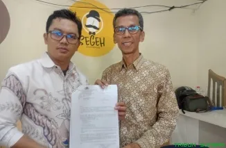 Amnasmen, mantan Ketua KPU Sumatera Barat, didampingi kuasa hukumnya Guntur Abdurrahman, memberikan keterangan pers terkait kasus dugaan penipuan dan penggunaan cek kosong yang menimbulkan kerugian lebih Rp1 miliar. (Foto: Ist)