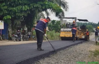 Alat berat mulai menghamparkan aspal di Jalan Poros Koto Gadang, Dharmasraya. (Foto: Ist)