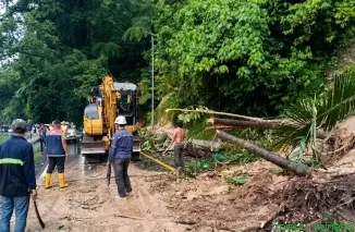 Petugas gabungan mengerahkan alat berat membersihkan material longsor berupa tanah, bebatuan, dan pepohonan yang menutup total badan jalan nasional Lembah Anai, Rabu (29/7/2026). (Foto: Ist)