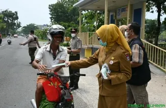 Kepala Pelaksana BPBD Kota Padang Hendri Zulviton beserta jajaran dan Kelompok Siaga Bencana membagikan masker secara gratis kepada warga dan pengguna jalan di depan Balai Kota Padang, Senin (7/9/2026). (Foto: Ist)