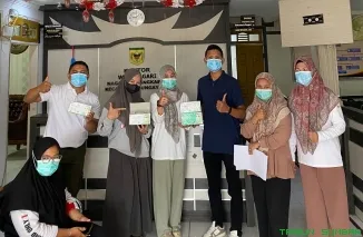 Kepala UPT Puskesmas Sungayang Iranovita Dewi serahkan bantuan masker ke lima nagari wilayah kerja. (Foto: Ist)
