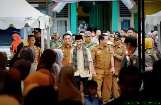 Wakil Bupati Solok Selatan Yulian Efi menyerahkan bantuan seragam sekolah gratis bagi 3.006 siswa TK--SLTP. (Foto: Ist)