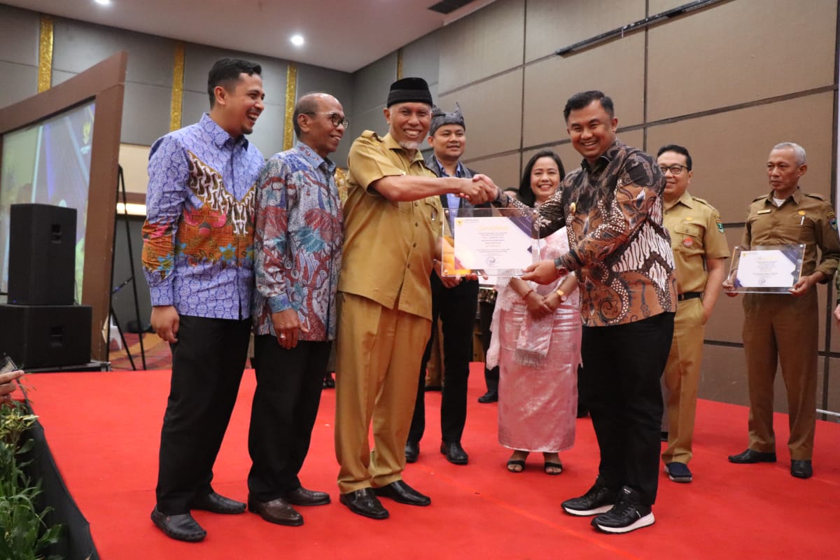 Bupati Dharmasraya Sutan Riska terima sertifikat prediket INFORMATIF yakni pengakuan tertinggi pengelolaan informasi publik dari Gubernur Sumbar Mahyeldi disaksikan Ketua KI Sumbar (kiri) dan HM  Nurnas (dua dari kiri) pada AKIP Sumbar 2022, Senin 12 Dese