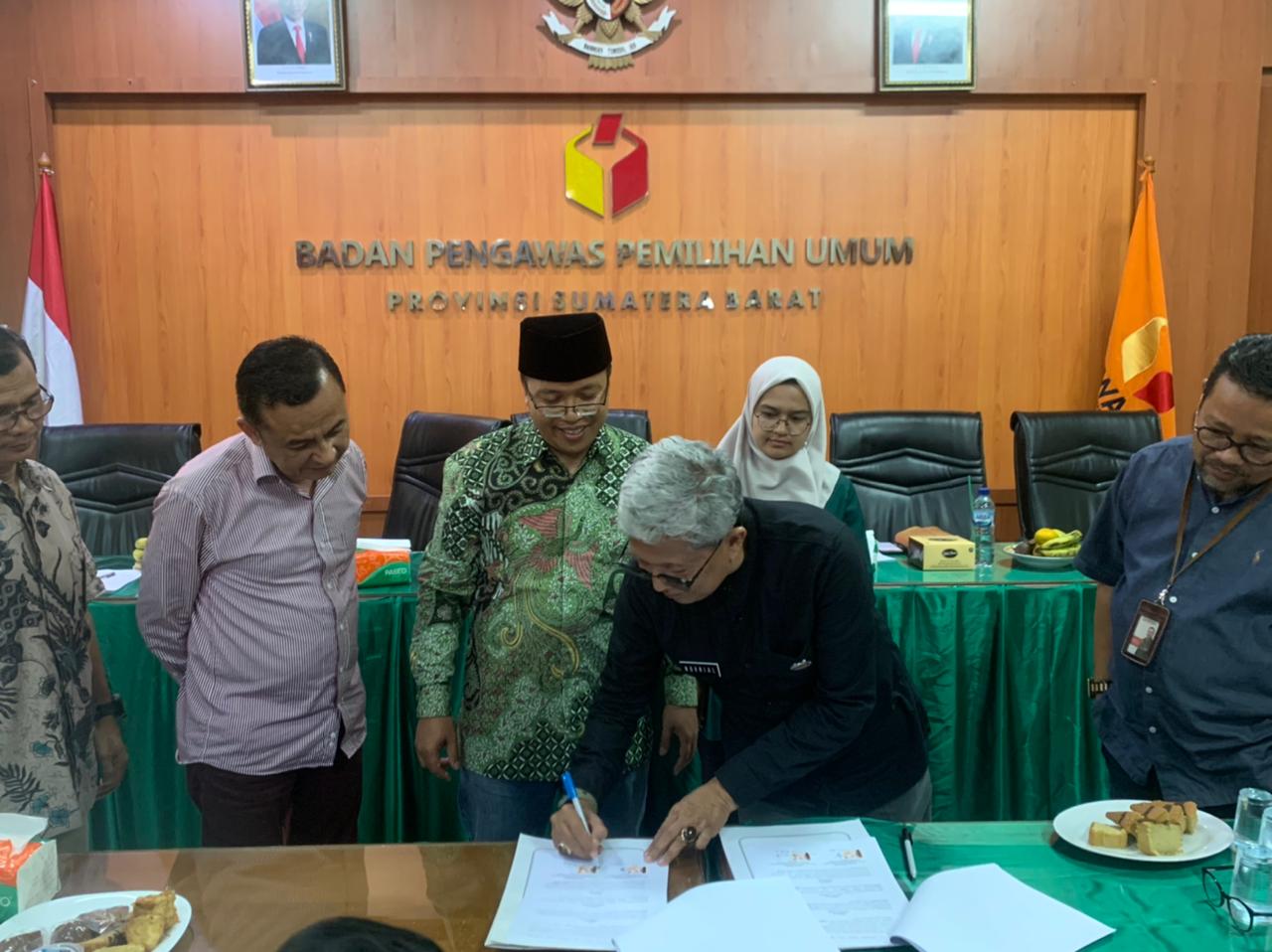 Kadis Arsip dan Perpustakaan Novrial tekan MoU arsip dengan Ketua Bawaslu Sumbar Alni, Jumat 23 Desember 2022, di Jalan Pramuka Kota Padang. (ck) 
