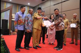 Bupati Dharmasraya Sutan Riska terima sertifikat prediket INFORMATIF yakni pengakuan tertinggi pengelolaan informasi publik dari Gubernur Sumbar Mahyeldi disaksikan Ketua KI Sumbar (kiri) dan HM  Nurnas (dua dari kiri) pada AKIP Sumbar 2022, Senin 12 Dese