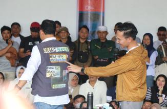 Ibrahim tengah menunjukan tulisan di jacket yang dipakai Anies Baswedan saat awal Desak Anies di Batusangkar, 3/1-2023. (riko)