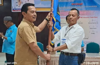 Teks Foto : Ketua PWI Sumbar Widya Navies (kiri) menyerahkan bendera PWI ke Ketua PWI Tanah Datar terpilih, Chandra Antoni, Sabtu (25/10/2025). IST